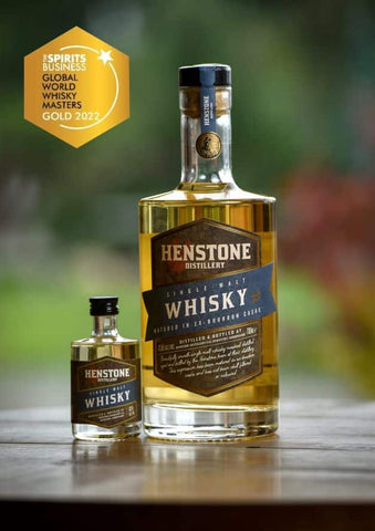 An image of henstone gold whisky next to a miniature whisky bottle with a gold stamp 2022 award