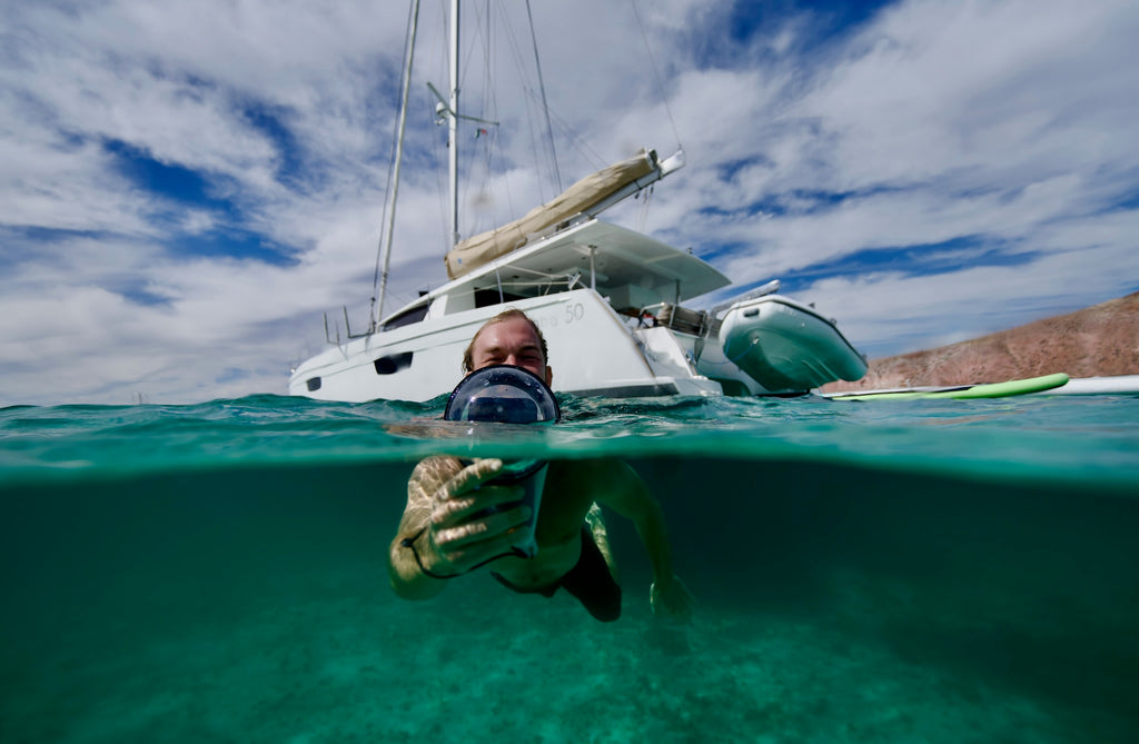 Nageur utilisant un smartphone sous l'eau avec un boîtier étanche Outex près d'un bateau