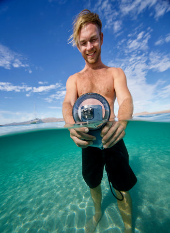 Model showing the Outex waterproof phone case on a beach in the water