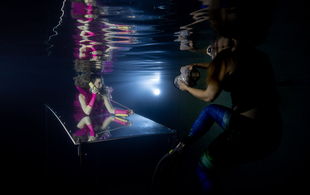 Waterproof lights for underwater photography of a model in a pool with pink dress by Kristina Sherk using Outex housing system BTS