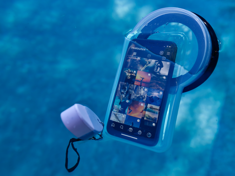 waterproof phone case floating in a pool half underwater