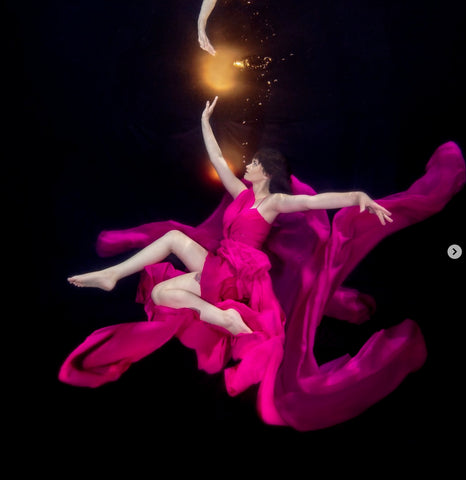 Underwater model wearing purple dress photographed by Outex ambassador Lori Probst