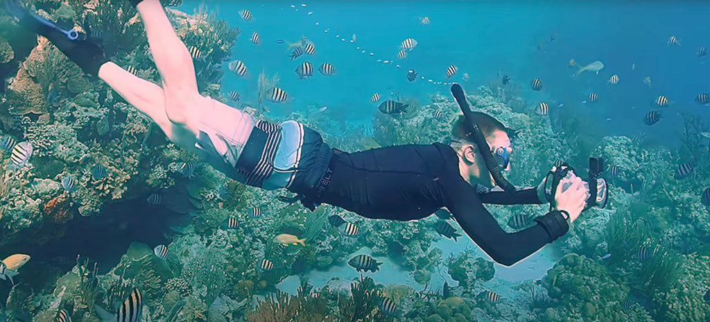 Snorkeler nadando com caixa subaquática Outex para câmera e GoPro