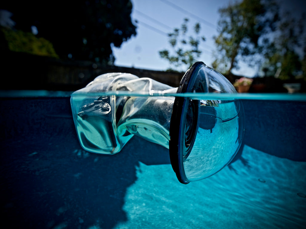 Boîtier de caméra sous-marine Outex flottant dans une piscine avec objectif Sony A7r4 et 12-24 mm f/2.8 à l'intérieur