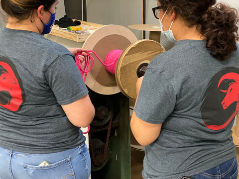 Mujeres de Ravenox en una fábrica fabricando cuerdas de algodón retorcidas de color rosa intenso