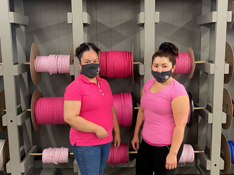Trabajadoras de fábrica Ravenox posan frente a una cuerda rosa