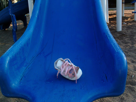 Child's shoe slipping off while playing on a slide - Ensuring secure footwear is essential for safety.