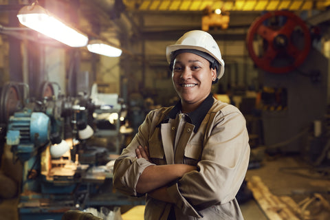 Trabajadora de fábrica sonríe con casco y gafas