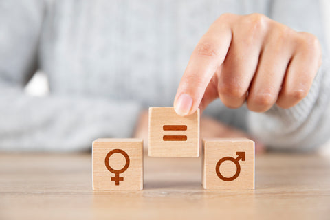 女性手在性别标志之间放置相等的块