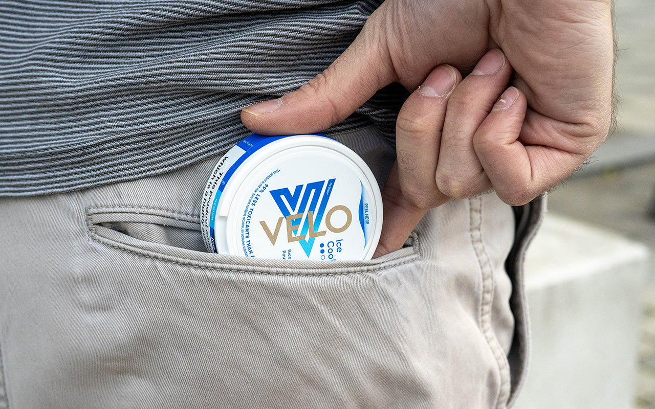 A person reaching into their back pocket for nicotine pouch