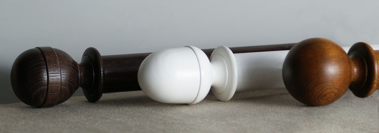Banner Image showing three wooden curtain poles on table.