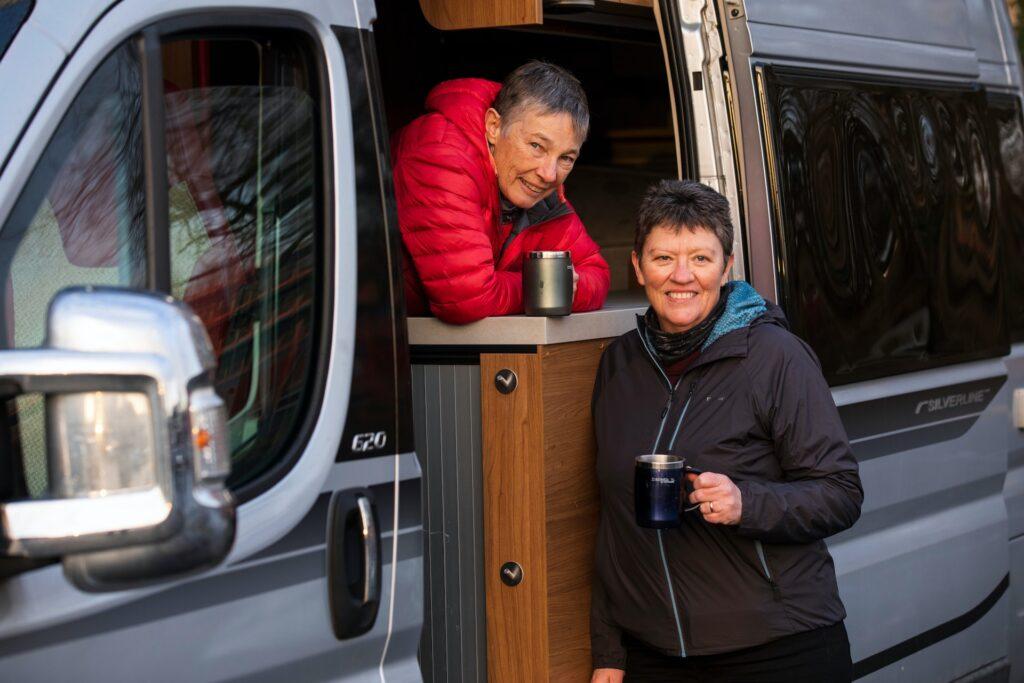A couple traveling in an RV takes a break to enjoy a cup of coffee.