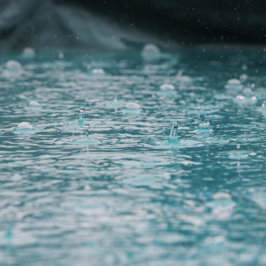 Close up of rain softly falling on pavement. The sound of PInk Noise is often compared to falling rain.