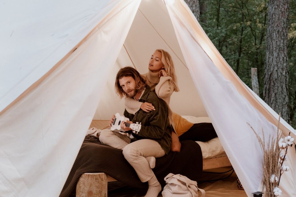 A young couple relaxes together in their glamping tent. 