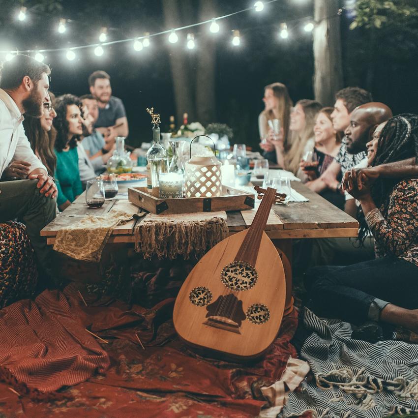 A group of people around a table with drinks in the evening at a glamping resort.