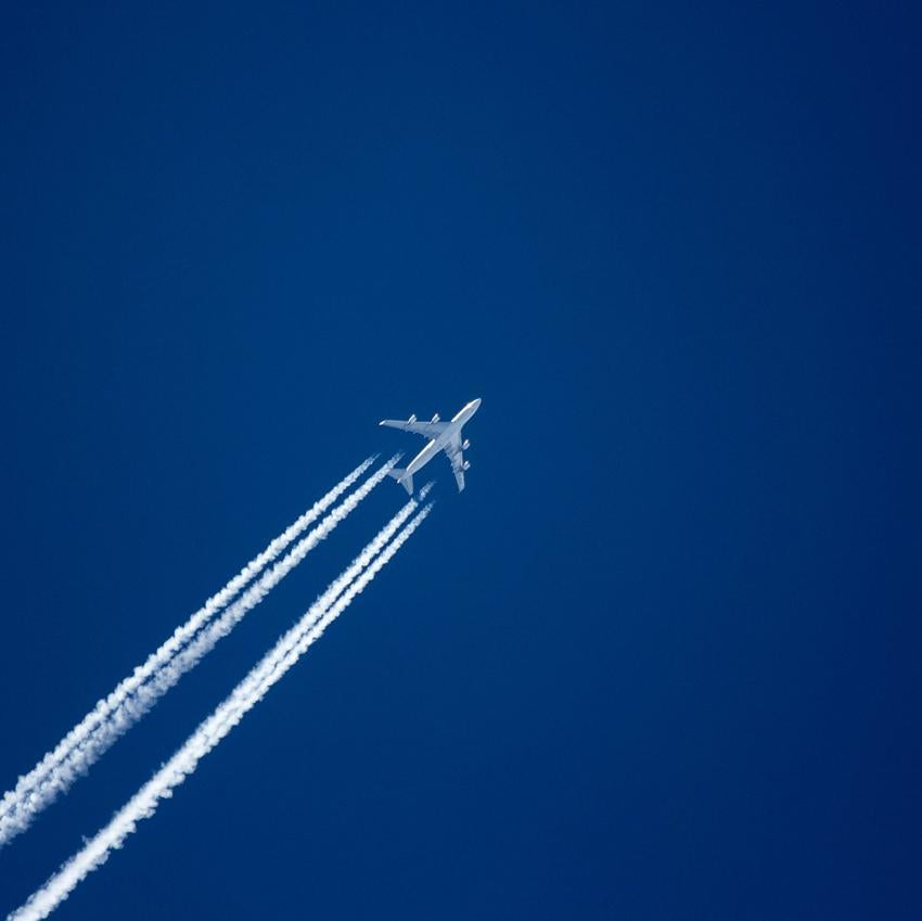 Airplane flying across the sky leaving a white trail