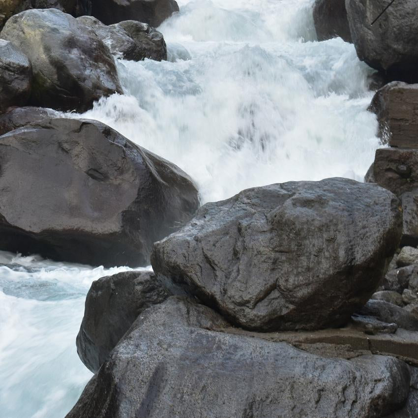 Close up of rushing river water crashing on large rocks - brown noise emulates the sound of a rushing river.