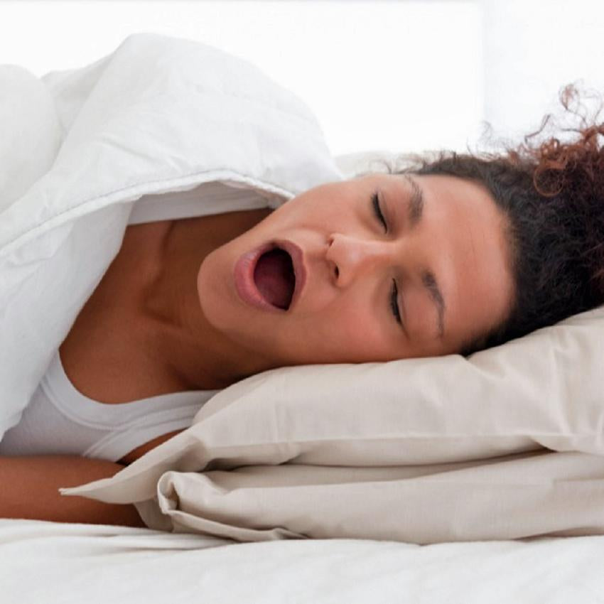 Close up of woman sleeping on side, mouth wide open, snoring
