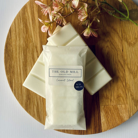 wax melt stap bars on a round placemat with flowers in their packaging