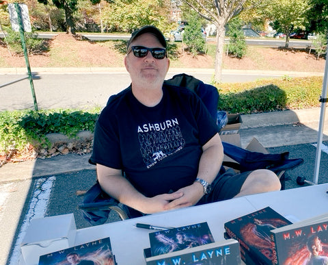 Mike selling books at an outdoor comic con.