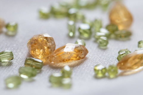 light green crystals scattered on a table with other crystals