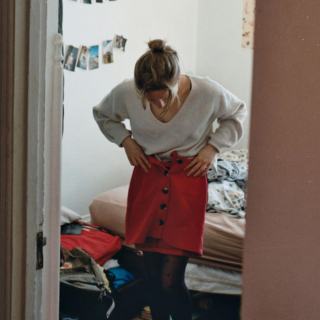 a girl trying on a red skirt