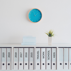 Labelled folders on white shelf