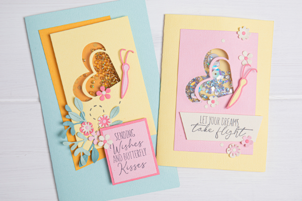 A blue card with the Heart Shaker Panes and Butterfly Framelits and Stamps Set, with another yellow card using the same items.