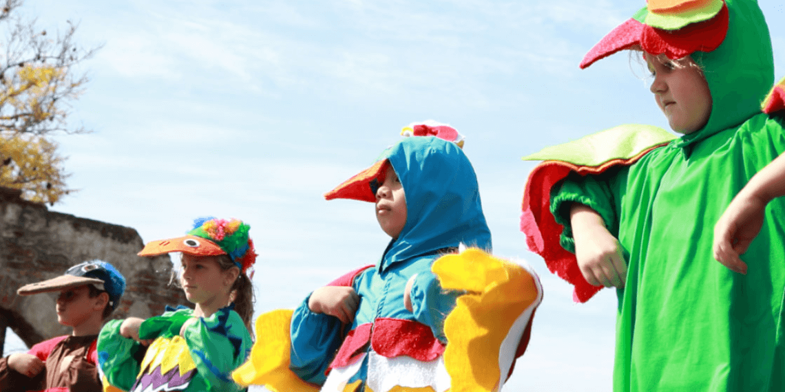 Image shows young parade attendees dressed as birds, celebrating the return of the swallows during the Swallows Day Parade in San Juan. The children are in colorful, bird-themed costumes, highlighting the joyful and imaginative spirit of the event as they participate in the festivities.