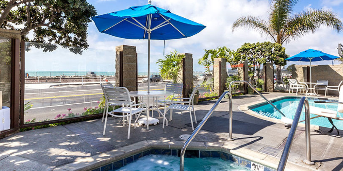 Daytime view from the pool area of Capistrano Seaside Inn, featuring a scenic ocean view and the Pacific Coast Highway (PCH) in the distance, creating a tranquil and coastal atmosphere.