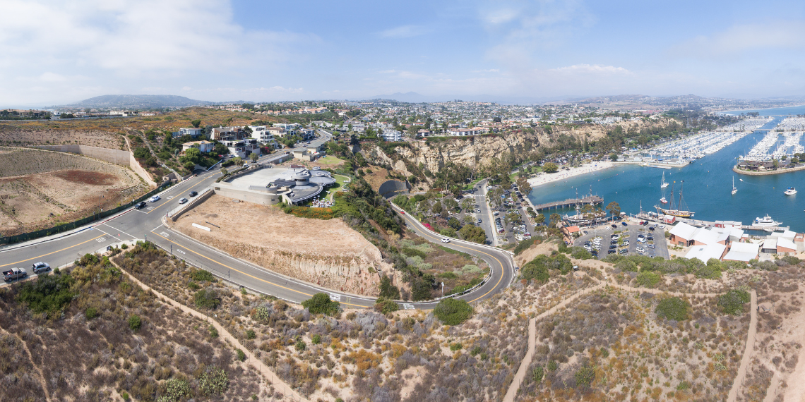 An aerial view of Dana Point Harbor on a sunny day, revealing a stunning vista ideal for biking and outdoor exploration.