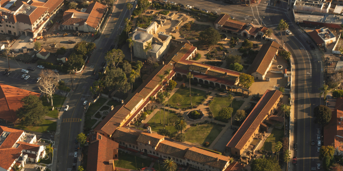 An aerial view of San Juan Capistrano bathed in the warm golden hues of the setting sun, highlighting the city's beauty and tranquility during golden hour.