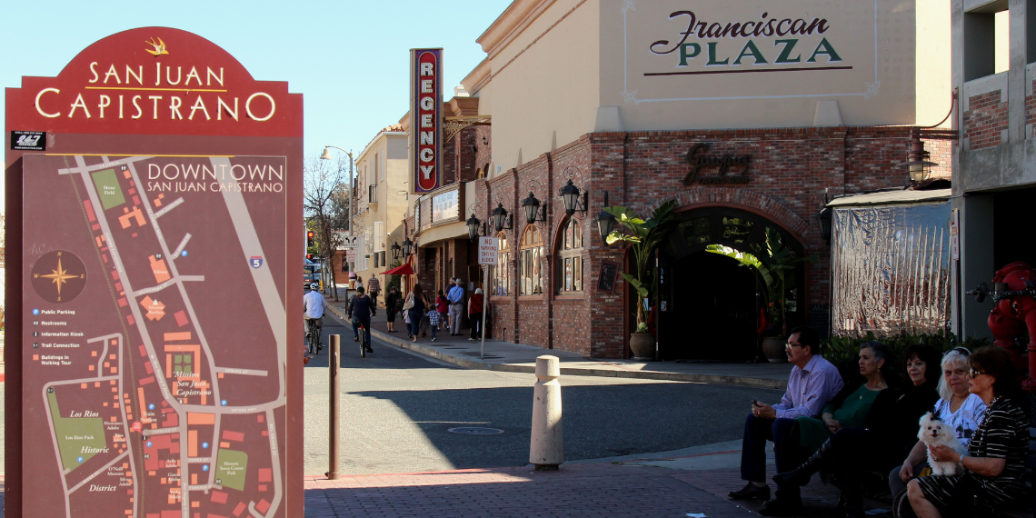 An image capturing the charming streets and historic buildings of Downtown San Juan Capistrano, bustling with activity