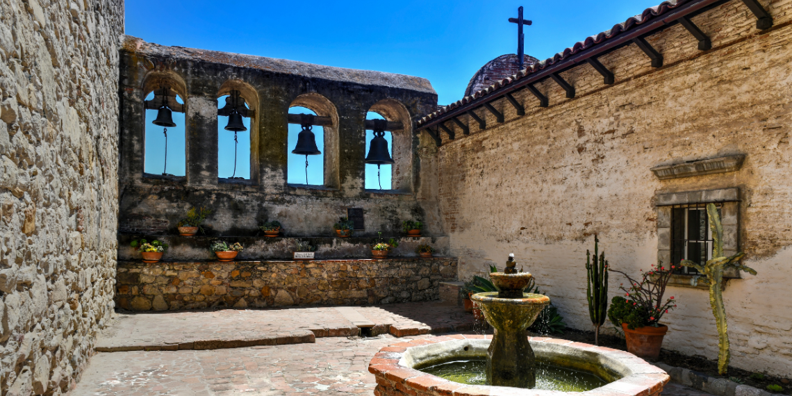 San Juan Capistrano Mission Bells and Fountain: An enchanting courtyard scene featuring the iconic mission bells and a tranquil fountain, blending history and serenity in Southern California.