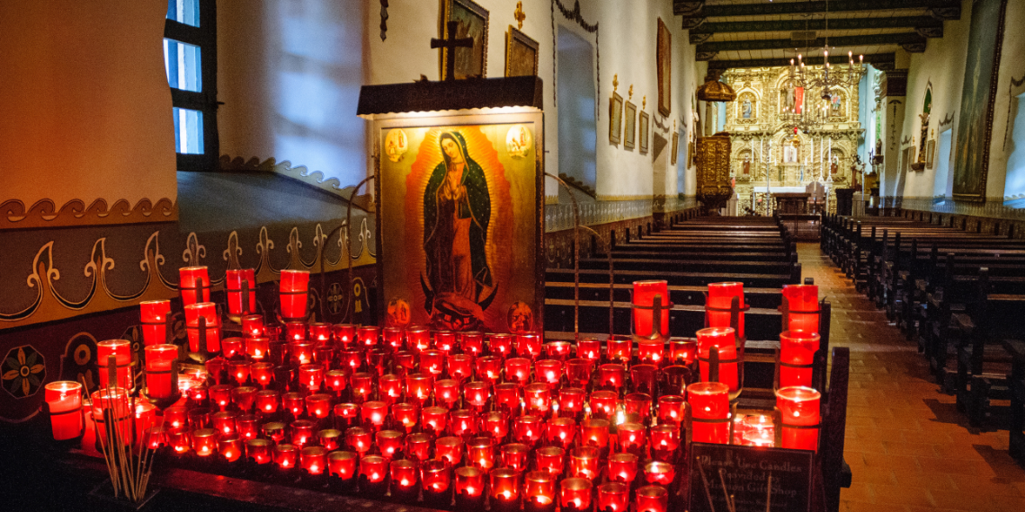 Mission San Juan Capistrano Church Interior: Illuminated prayer candles casting a warm glow in the historic church, creating an ambiance of spiritual reverence and tranquility.
