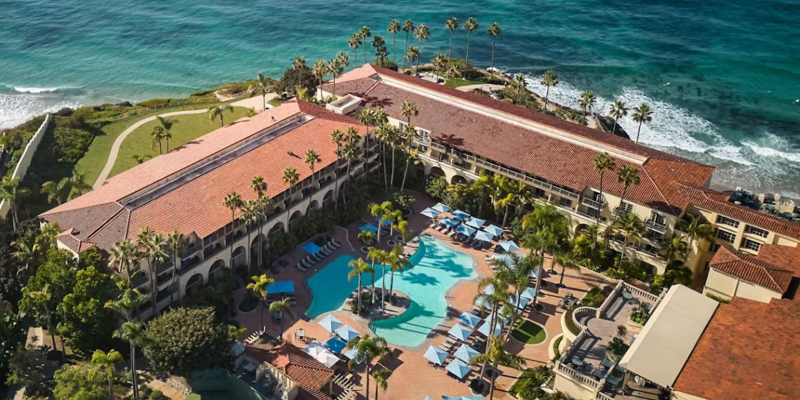 Bird's-eye view of The Ritz-Carlton, Laguna Niguel, showcasing the luxurious resort's pool area and stunning ocean view on a bright and sunny day.