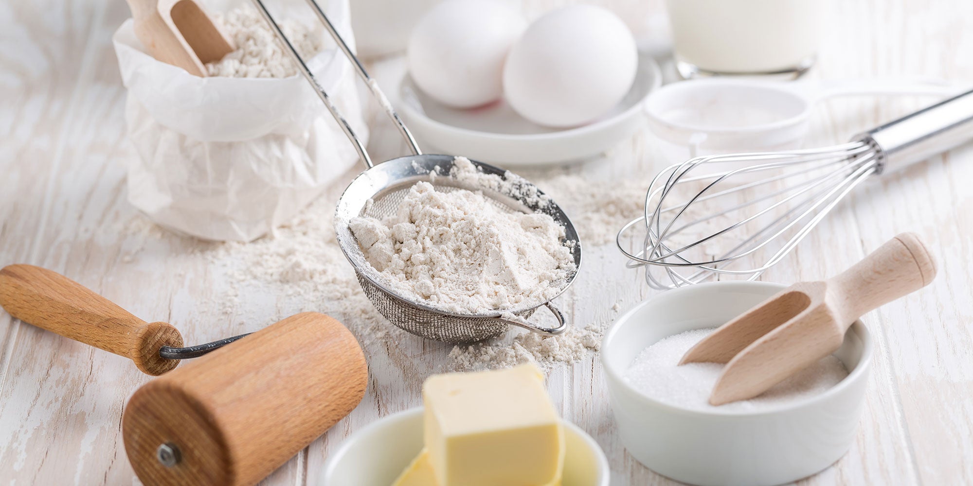 photo of baking ingredients including flour, eggs, butter, sugar