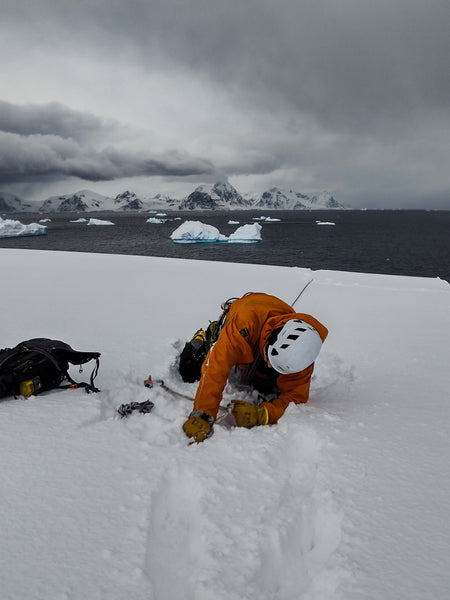 Figure 4 – A photo of my partner trying not to be pulled backwards as I hang off the cliff, taken during crevasse rescue training. Photo credit: Mark Chambers.