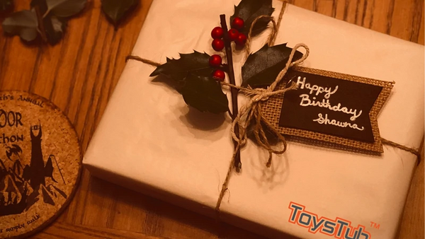 a packed square gift lying on a table with Toystub logo on it