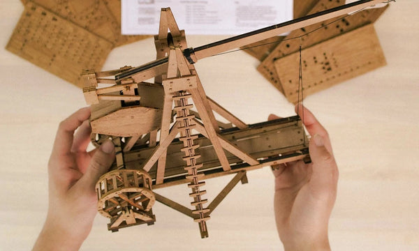 two hands holding a counterweight trebuchet finished model