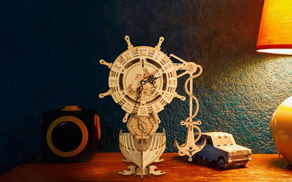 finished ship clock model on table with lamp and toy car model
