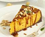 A slice of pumpkin orange cheesecake drizzled with caramel and candied nuts - Renee's Garden 