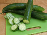2 whole cucumbers and one that is sliced on a green cutting board - Renee's Garden