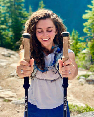 A woman hiking with a pair of hiking staff.