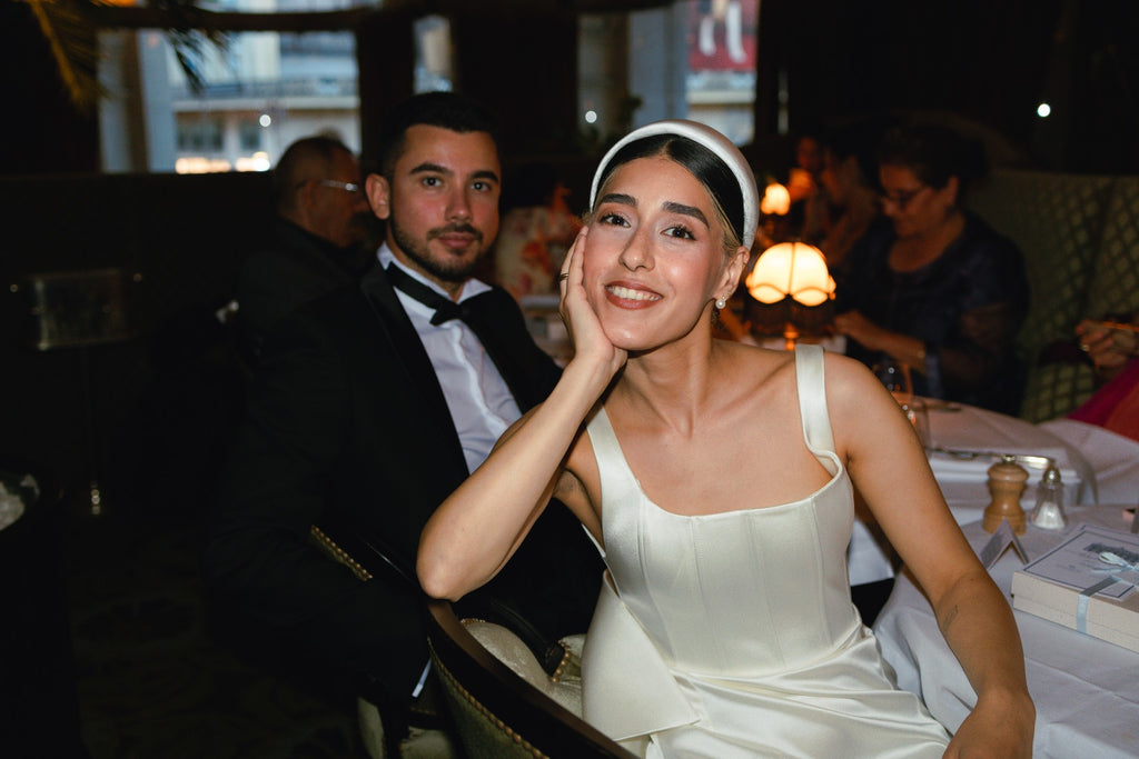 A cool bride wears an ivory padded headband in a Paris restaurant