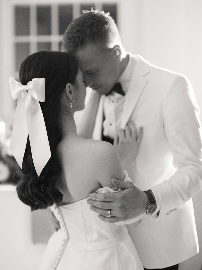 A white satin hair bow for a modern romantic bride and groom