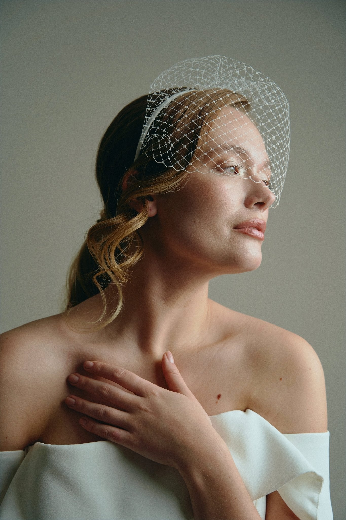 Bride wears ivory birdcage veil headband