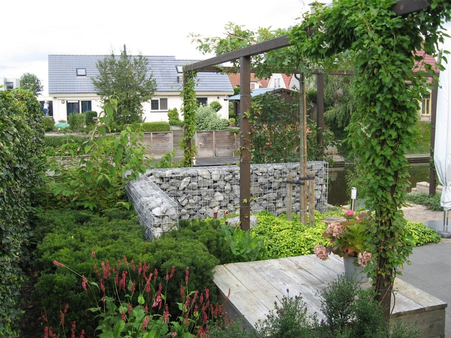 houten pergola door de tuin geeft diepte