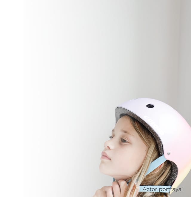 a photo of a young girl putting on a bicycle helmet