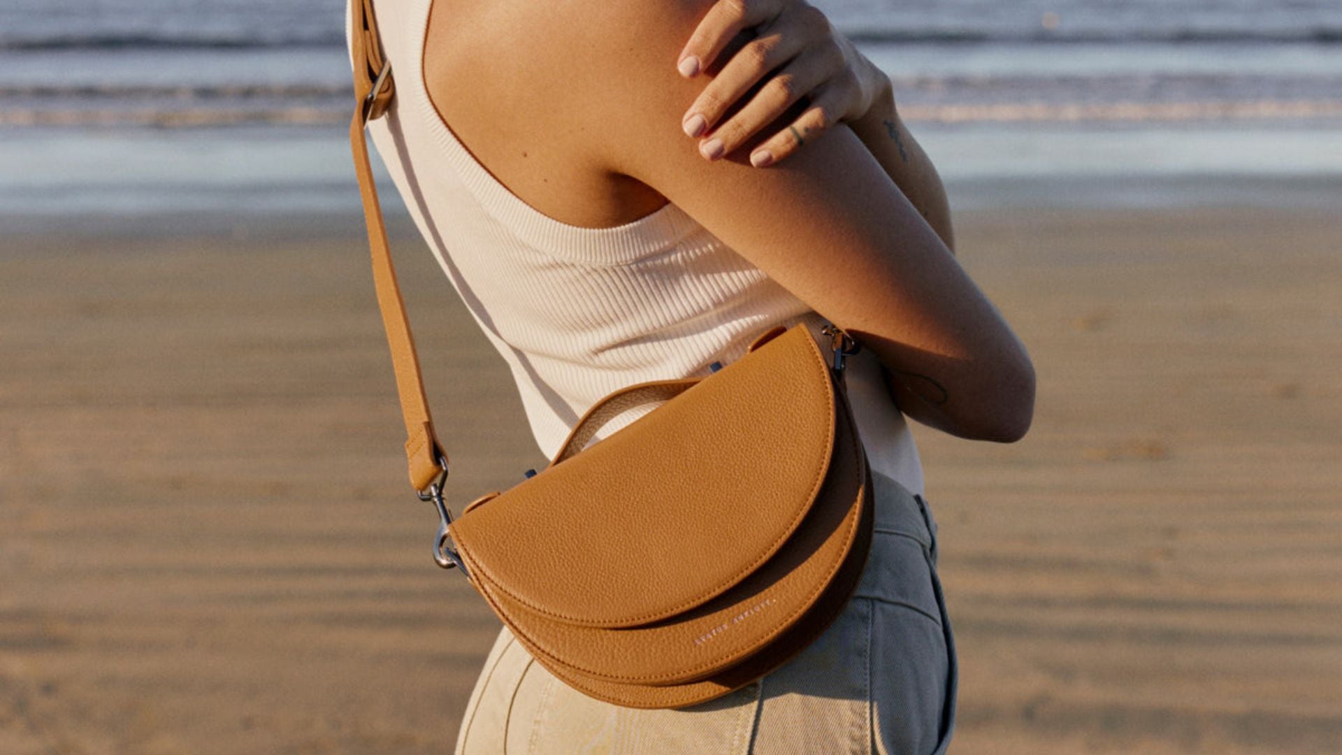 Brown leather Status Anxiety bag on a woman's hip